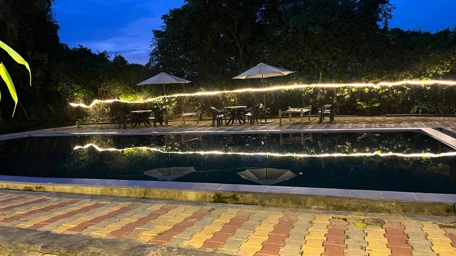 The swimming pool lined with fairy lights in the evening